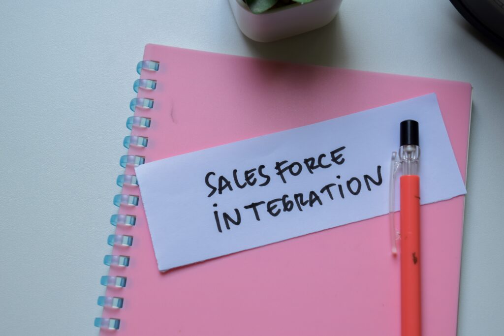 Concept of SalesForce Integration write on sticky notes isolated on Wooden Table.