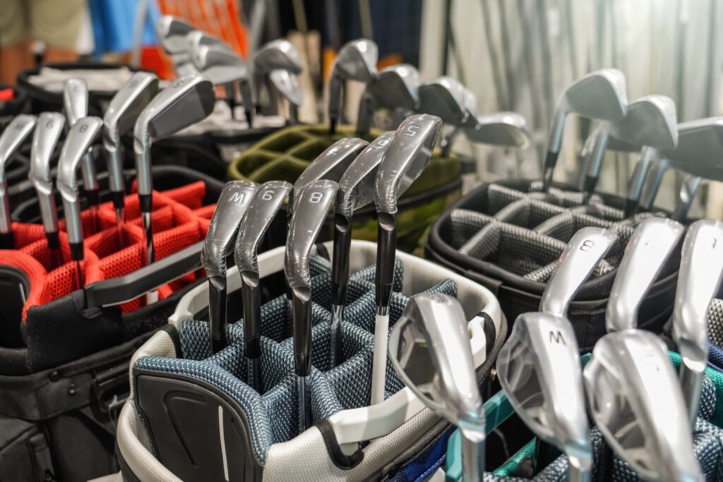 Various colors of golf equipment and clubs